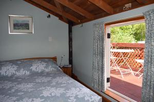 Schlafzimmer mit einem Bett und einer Glasschiebetür in der Unterkunft Dylans Country Cottages in Kaikoura