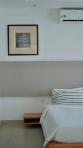 1 dormitorio blanco con 1 cama y una foto en la pared en Dreamers House Vung Tau - a beachfront villa, en Vung Tau