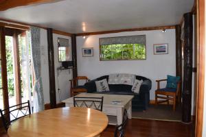 een woonkamer met een bank en een tafel bij Dylans Country Cottages in Kaikoura