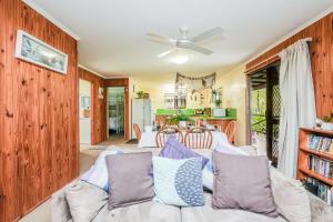 a living room with a couch and a ceiling fan at The Little House - Pet-friendly beach cottage in Agnes Water