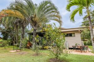 a house with palm trees in the yard at The Little House - Pet-friendly beach cottage in Agnes Water