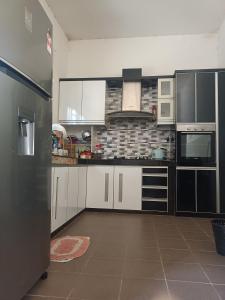 a kitchen with white cabinets and a brick wall at AV HOMESTAY in Kuantan