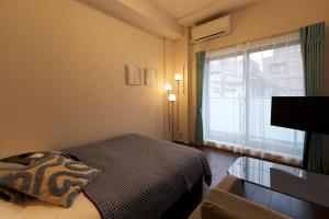 a small bedroom with a bed and a window at G-Stage 01 IKEBUKURO in Tokyo