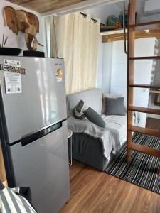 een woonkamer met een koelkast en een bank bij BRAND NEW Beachfront Tiny Home Oniro in Koh Samui 