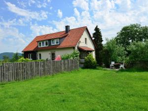 a house with a fence in a yard at apartment in the Hochsauer region quiet location in Stormbruch