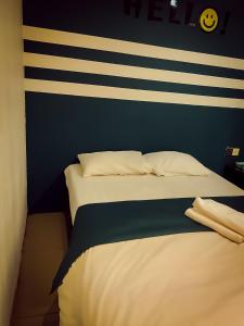 a bed in a room with a striped wall at V Hotel Sri Gombak (Previously MyHome Hotel) in Batu Caves