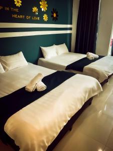 two beds in a room with towels on them at V Hotel Sri Gombak (Previously MyHome Hotel) in Batu Caves