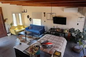 uma sala de estar com um sofá azul e uma televisão em Maravilloso loft serrano em Cuesta Blanca