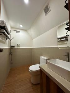 a bathroom with a white toilet and a sink at Diwata Nature Resort in San Pablo