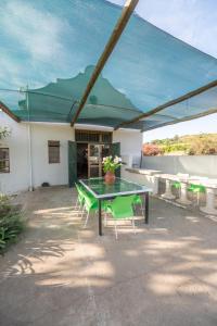 a patio with a table and chairs and a building at Merwespont Guesthouses#DieHouthuis#Die Wyntenke#A Snoozer's Cottage# in Bonnievale