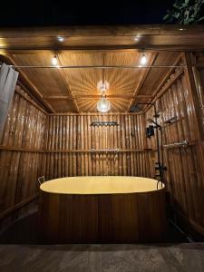 a bath tub in a wooden room with a light at Diwata Nature Resort in San Pablo