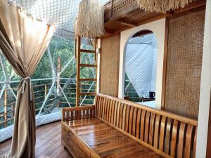 a room with a large window and a wooden bench at Diwata Nature Resort in San Pablo