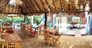 un restaurante con mesas y sillas de madera y un mural en hostal pakal, en Mazunte