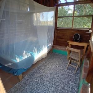 Habitación con cama, mesa y ventana en hostal pakal, en Mazunte