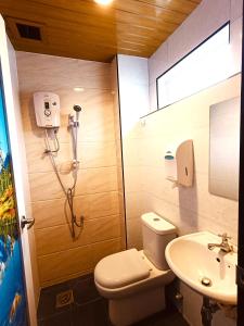 a bathroom with a shower and a toilet and a sink at HOTEL POP ASH in Brinchang