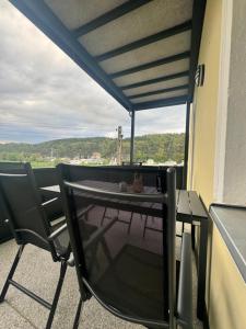 a table and chairs on a balcony with a view at Pension Hönel-Hof Bad Schandau in Bad Schandau
