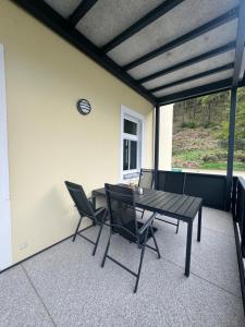 a table and chairs on a screened in porch at Pension Hönel-Hof Bad Schandau in Bad Schandau