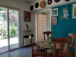 a dining room with a table and chairs and a window at Holiday Home Dark Green House in Chacras de Coria