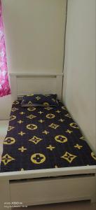 a bed with a black comforter with yellow skulls on it at Homestay Lumut in Lumut