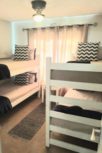 a bedroom with two bunk beds and a window at Laguna la Crete 214 in Uvongo Beach