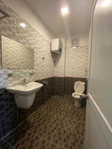 La salle de bains est pourvue d'un lavabo et de toilettes. dans l'établissement Nhà trọ LEGO Dormstay, à Hanoï