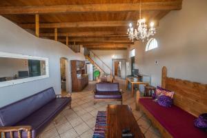 a living room with couches and a chandelier at Merwespont Guesthouses#DieHouthuis#Die Wyntenke#A Snoozer's Cottage# in Bonnievale