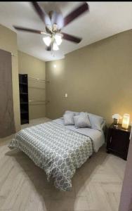 een slaapkamer met een plafondventilator en een bed bij Céntrico y Cómodo Departamento in Tampico