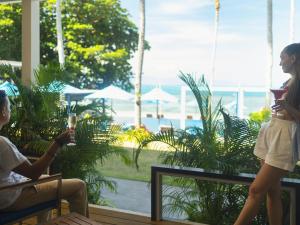 un homme et une femme debout devant une fenêtre dans l'établissement Explorar Koh Phangan - Adults Only Resort and Spa, à Haad Rin