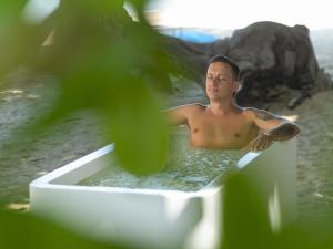 a man in a bath tub on the beach at Explorar Koh Phangan - Adults Only Resort and Spa in Haad Rin