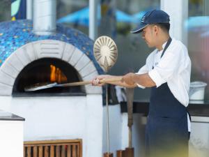 a man is cooking food in an oven at Explorar Koh Phangan - Adults Only Resort and Spa in Haad Rin
