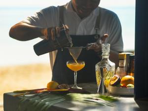 a man pouring a drink into a martini glass at Explorar Koh Phangan - Adults Only Resort and Spa in Haad Rin