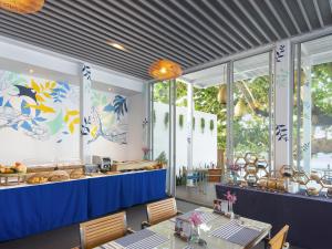 a restaurant with a blue counter and some tables at Explorar Koh Phangan - Adults Only Resort and Spa in Haad Rin