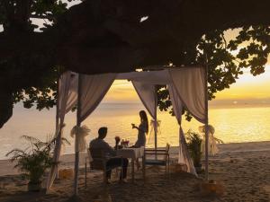 a couple sitting at a table under a tent on the beach at Explorar Koh Phangan - Adults Only Resort and Spa in Haad Rin