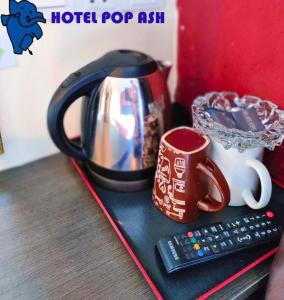 uma chaleira, uma chávena e um controlo remoto em HOTEL POP ASH em Brinchang