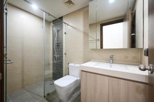 La salle de bains est pourvue de toilettes, d'un lavabo et d'une douche. dans l'établissement Khoahome Hà Đô Q10 2PN-3PN 2WC, à Hô-Chi-Minh-Ville