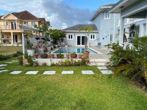 a backyard with a swimming pool and a house at Sea Shells in Nassau