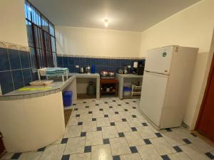 een keuken met een koelkast en een tegelvloer bij Nice family house with big rooms in Ica