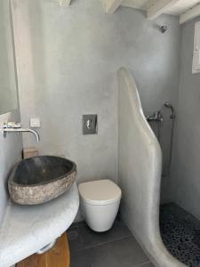 a bathroom with a large stone sink and a toilet at Anais in Mikonos