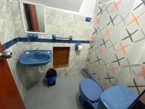 een badkamer met een blauwe wastafel en een toilet bij Nice family house with big rooms in Ica
