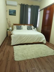 1 dormitorio con 1 cama blanca grande con alfombra en City Lodge en Rose Hill