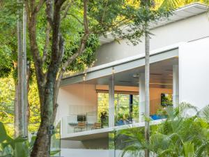a modern house with white walls and trees at Explorar Koh Phangan - Adults Only Resort and Spa in Haad Rin