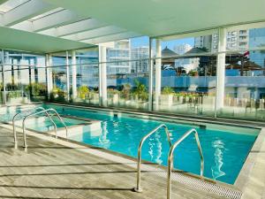 a large swimming pool in a building with glass windows at La Choza VIP Roja in Coquimbo