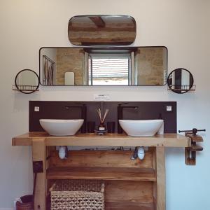 a bathroom with two white sinks and a mirror at Le Sourire du Troubadour - 8 chambres - Baignade à 300 m - Salle de jeux - Poêle à bois in Daglan