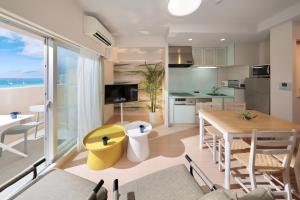 een keuken en een woonkamer met een tafel en stoelen bij City Life Miyako L'avenir in Miyako Island