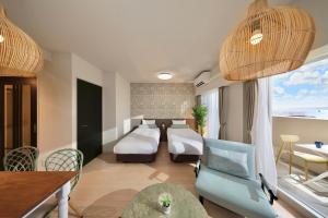 宮古島にあるシティライフ宮古ラブ二ールのベッド、テーブル、椅子が備わるホテルルームです。