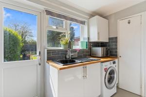 a kitchen with a sink and a washing machine at 3 BR 5 min walk from Hertfordshire University in Hatfield in North Mimms