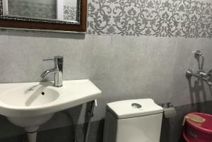 ein Badezimmer mit einem Waschbecken, einem WC und einem Spiegel in der Unterkunft Goroomgo Payal Lake View Mall Road Nainital in Nainital