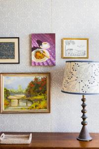stół z lampką i obrazami na ścianie w obiekcie Halcyon House w mieście Cabarita Beach