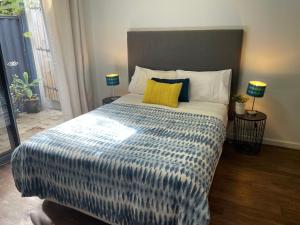 a bedroom with a bed with a blue and white comforter at Como Retreat - two bedroom villa in Perth