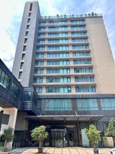 ein großes Bürogebäude mit vielen Fenstern in der Unterkunft Golden Tulip Zhong Xin Hotel Taichung in Taichung